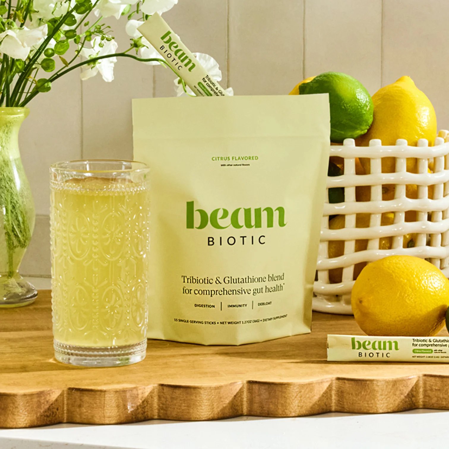Prepared Biotic drink with packaging, sachets and fruit nearby.