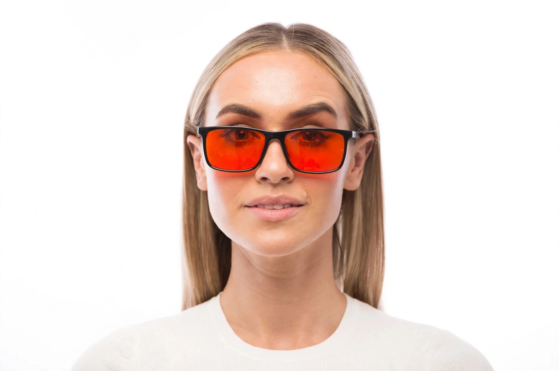 Woman wearing black framed glasses with orange lenses.
