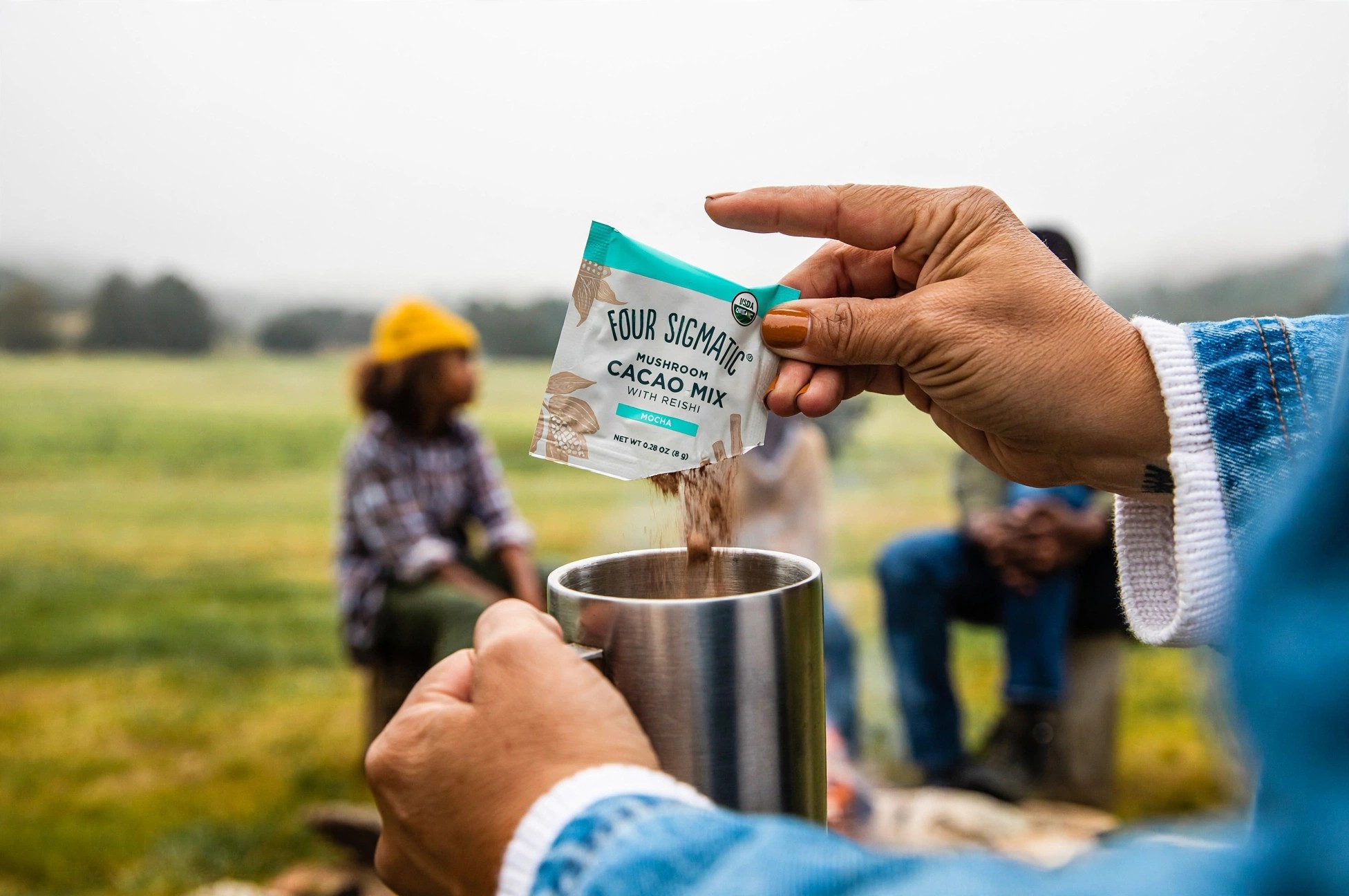 Cacao powder being poured from a sachet into a mug.