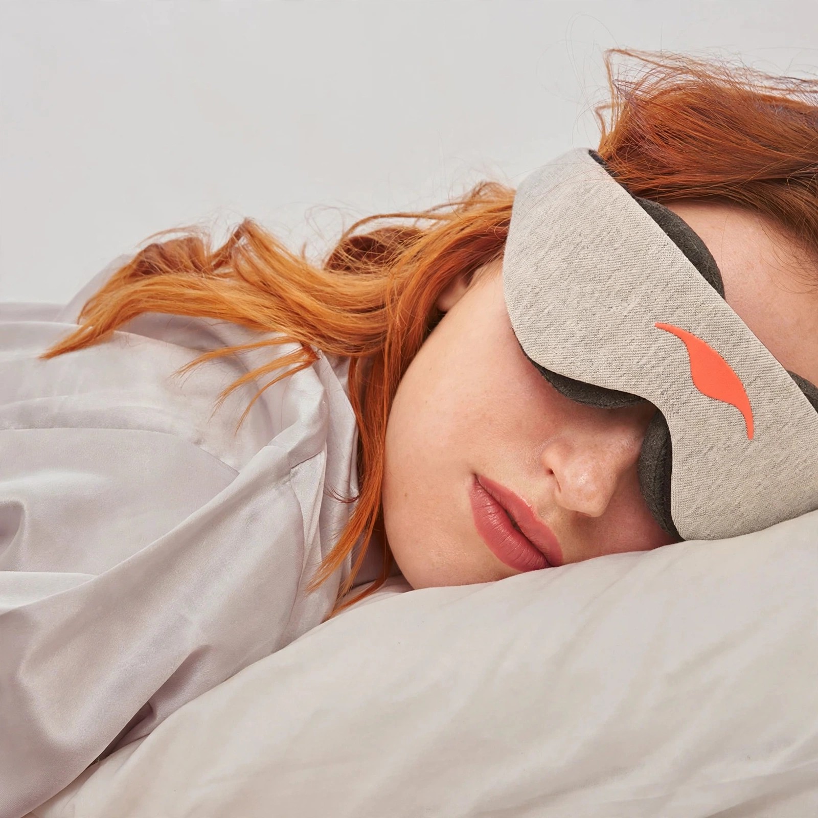 Woman sleeping on her side wearing a beige Manta mask.